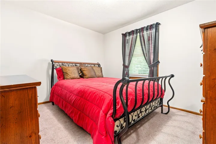 A well-lit room showcasing a window with blinds and drapes, perfect for tranquil repose.