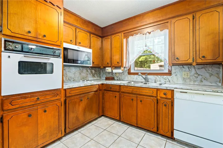Warm wood cabinetry and durable tile flooring define this functional kitchen space.