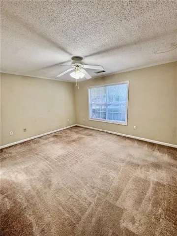 A well-lit bedroom with soft carpeting awaits your personal touch.
