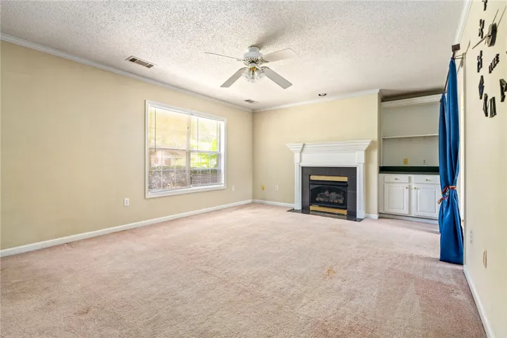 A comforting living area with a fireplace and built-in shelving offers a warm welcome.