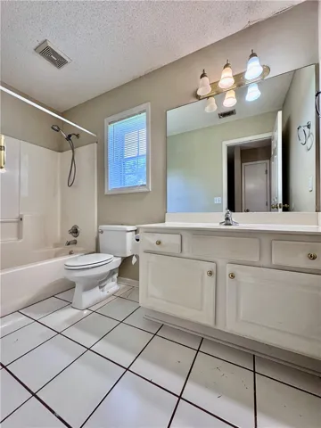 A well-lit bath features a large vanity and a shower-tub combination.