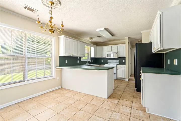 A well-equipped kitchen offers practical counter space and abundant cabinetry, perfect for daily routines.