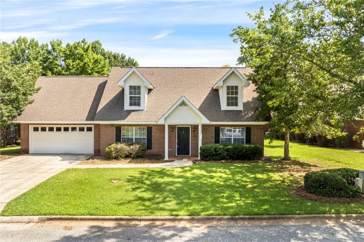 A classic brick exterior with dormer windows and a well-kept lawn invites you home.