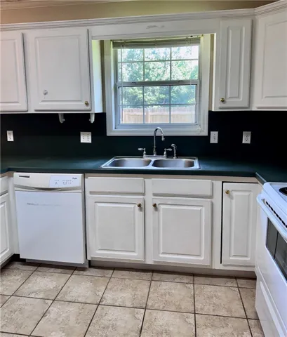 An inviting kitchen with bright cabinetry, a double basin sink, and ample countertop space.