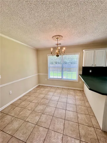 A classic chandelier illuminates this versatile dining area with durable tiled flooring.
