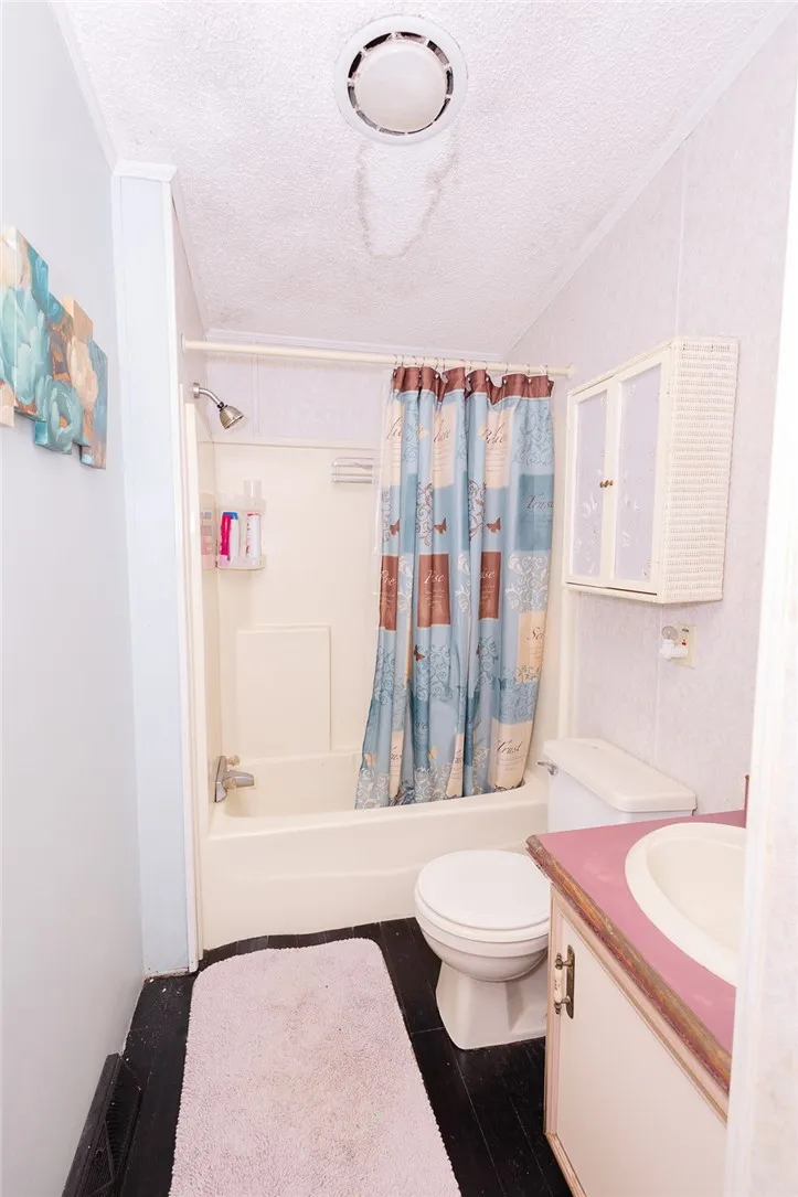 A compact bathroom offers a functional tub-shower combination and a vanity with basin.
