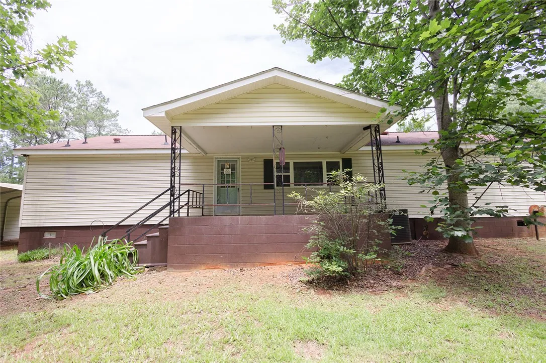 A welcoming front porch with decorative ironwork offers a serene outdoor space.