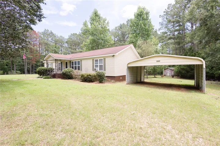 A welcoming home with ample outdoor space, featuring a convenient carport.