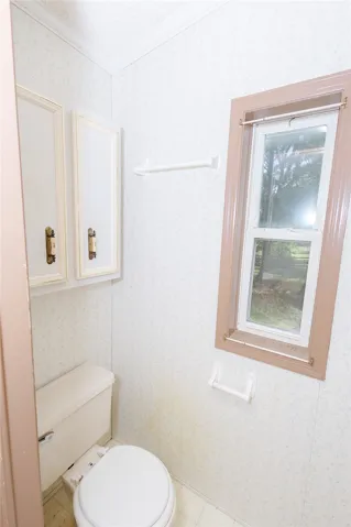 A window-lit lavatory features practical overhead storage and a towel bar.
