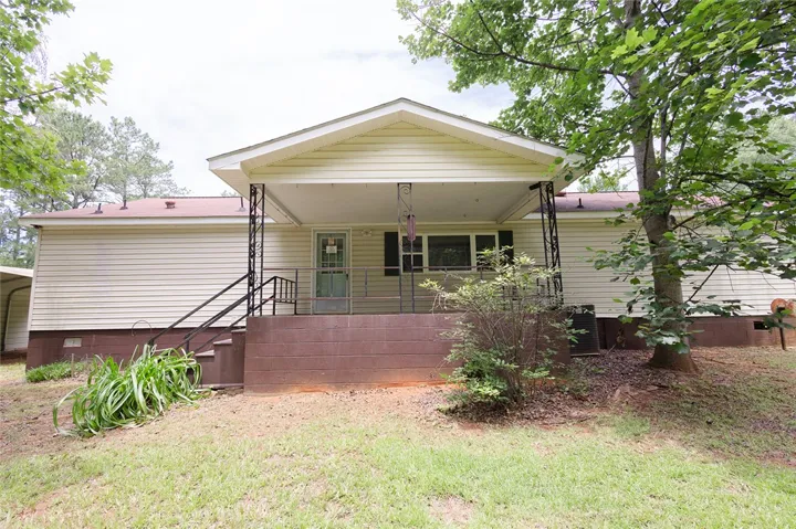 A welcoming front porch with decorative ironwork offers a serene outdoor space.