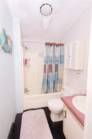 A compact bathroom offers a functional tub-shower combination and a vanity with basin.