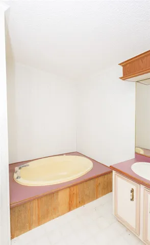 A built-in tub alongside a vanity offers a functional bathroom space.