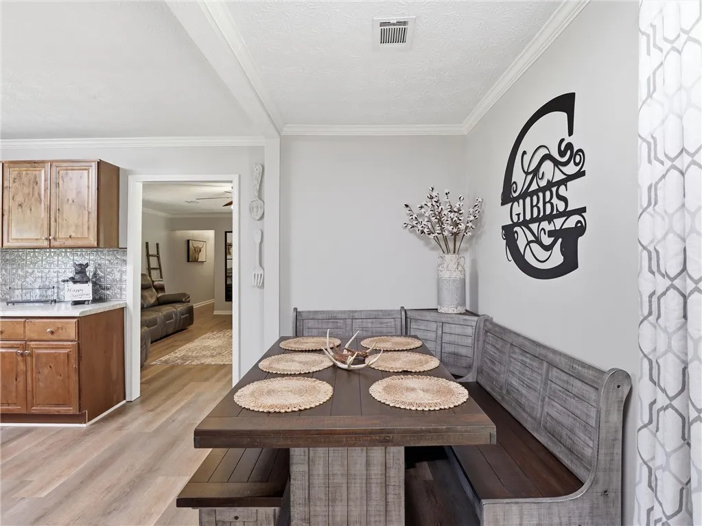 Custom banquette seating and natural wood finishes create a warm, inviting dining space adjacent to the kitchen.