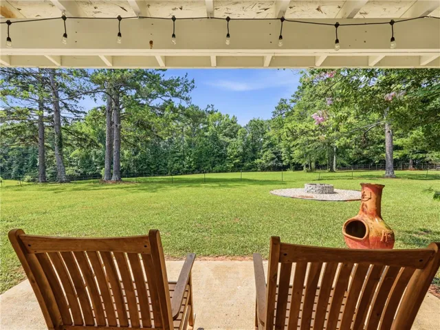A spacious yard perfect for entertaining, with a fire pit and mature trees for a private setting.