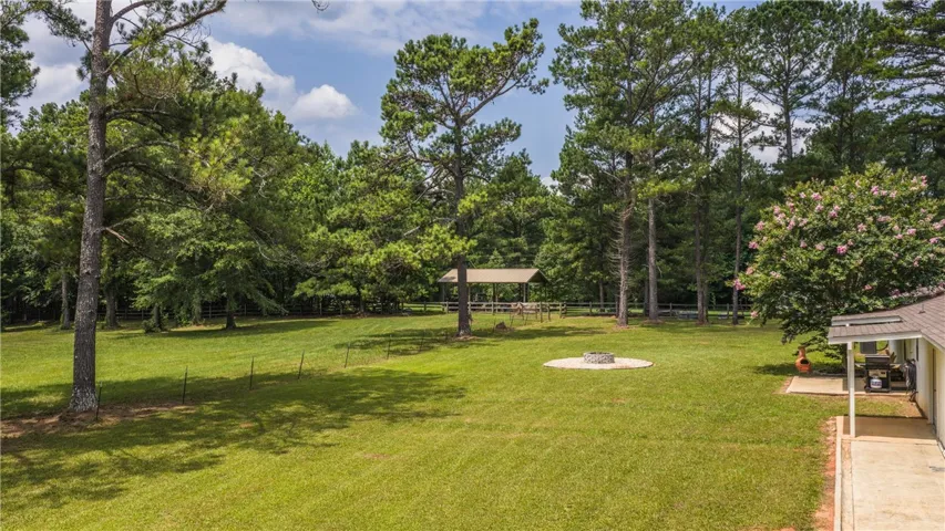 A spacious yard with mature trees and a charming outdoor gazebo, perfect for relaxation or entertaining.