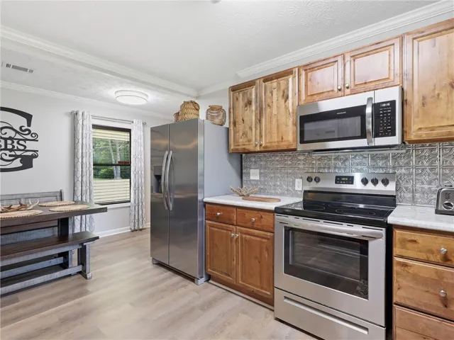 Culinary delights await in this inviting kitchen, boasting durable laminate flooring and essential modern appliances.
