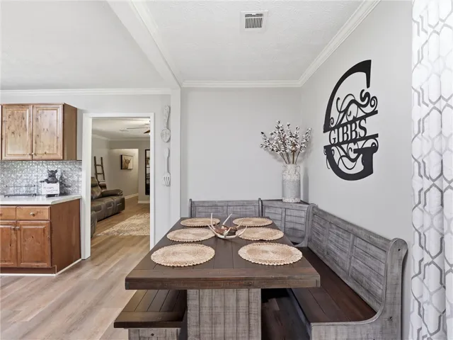 Custom banquette seating and natural wood finishes create a warm, inviting dining space adjacent to the kitchen.