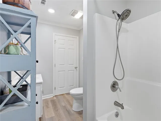 A well-appointed bathroom features a shower-tub combo and durable flooring, offering both functionality and style.
