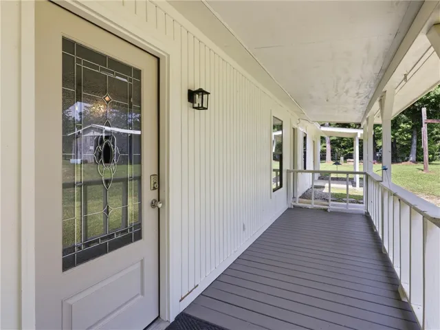 A welcoming front porch features a decorative glass entry door and ample space for outdoor enjoyment.