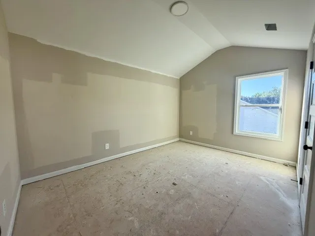 A window-filled room with vaulted ceilings, ready for personalized touches.