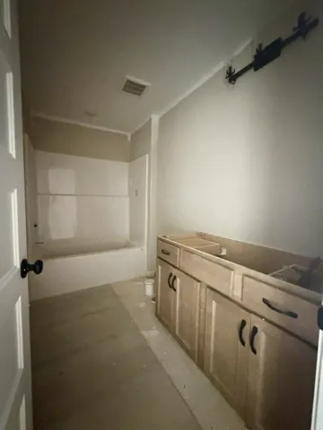 Ready for custom finishes, this bathroom offers a functional layout with a tub and vanity space.