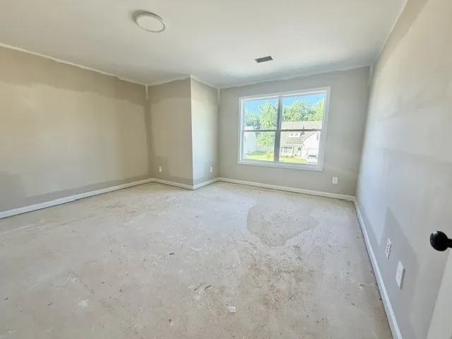 A versatile space awaits customization, offering abundant natural light through a large window.