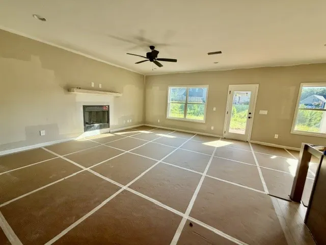 A spacious living room features a fireplace and multiple windows, filling the area with natural light.
