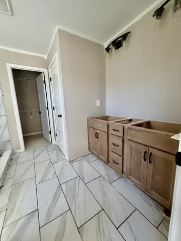 Ready for personalized touches, this bathroom presents a spacious layout and elegant tile flooring.