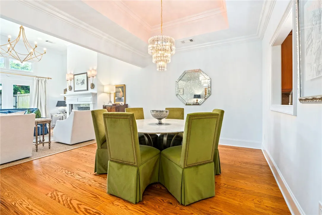 A refined dining room with rich hardwood floors flows seamlessly into a bright living space.