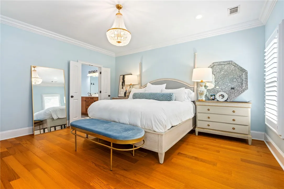 Elegant crown molding and rich hardwood flooring define this tranquil bedroom retreat.