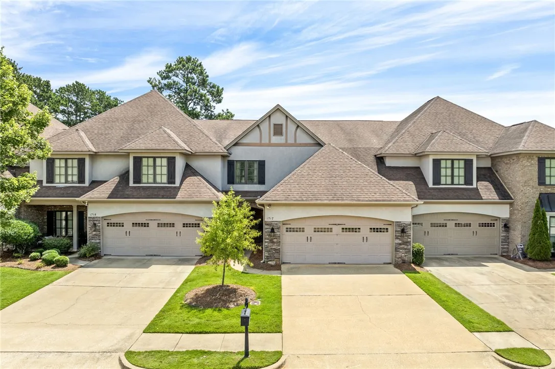 A row of inviting townhomes featuring well-maintained landscapes and dual garage doors.