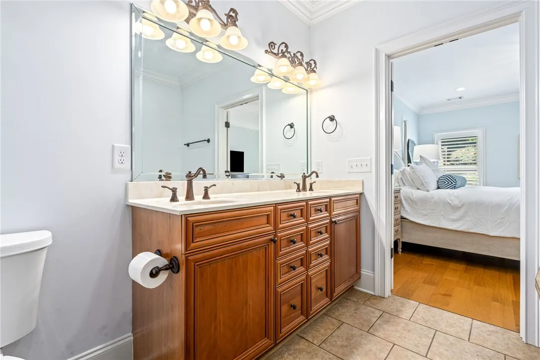 Double vanity with ample storage and elegant fixtures complements this functional bathroom.