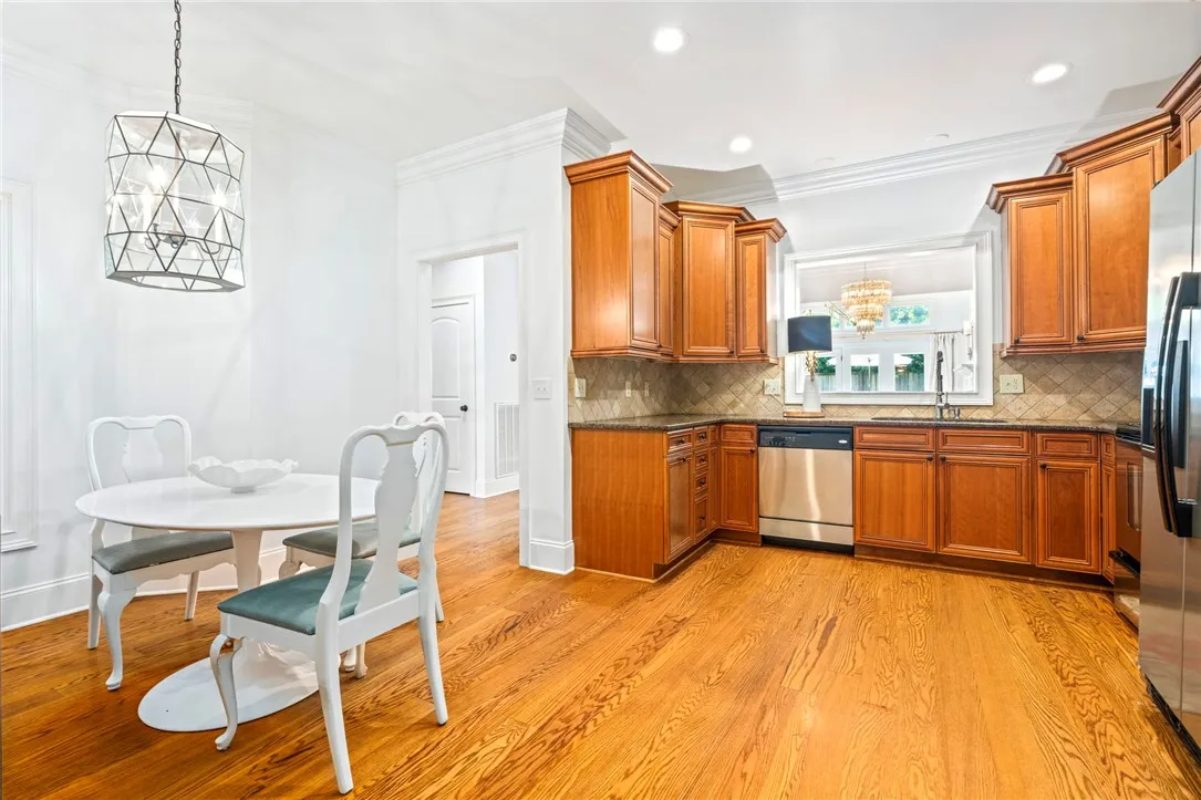 A well-lit kitchen with rich wood cabinetry and gleaming hardwood flooring.