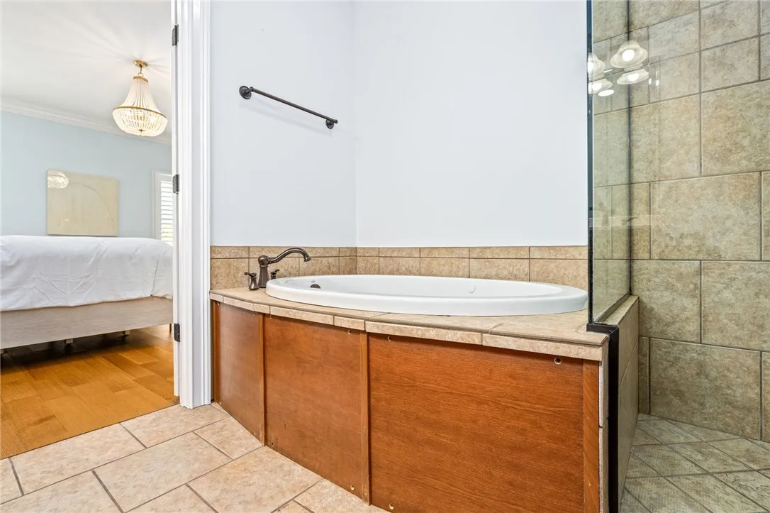 Indulge in a tranquil bathing experience with this inviting built-in tub and adjacent shower.