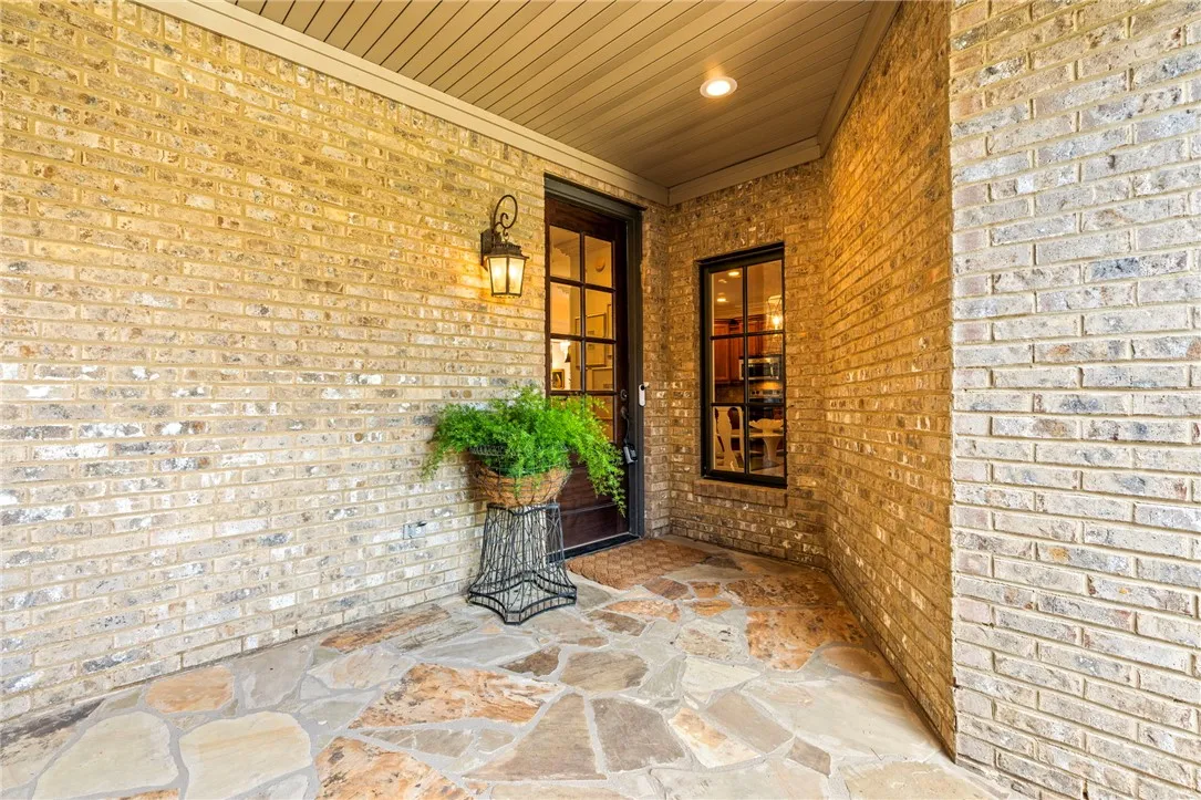 A welcoming brick facade with a covered entry, featuring a striking flagstone patio.