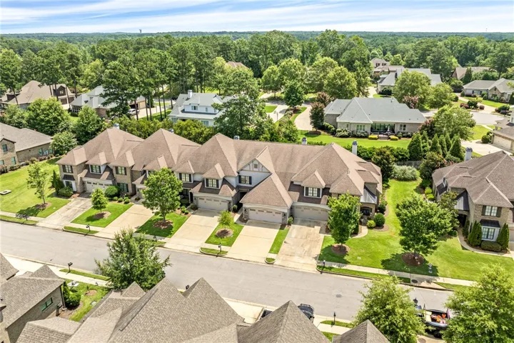 An aerial perspective reveals a harmonious community nestled amidst verdant landscapes, offering serene living.