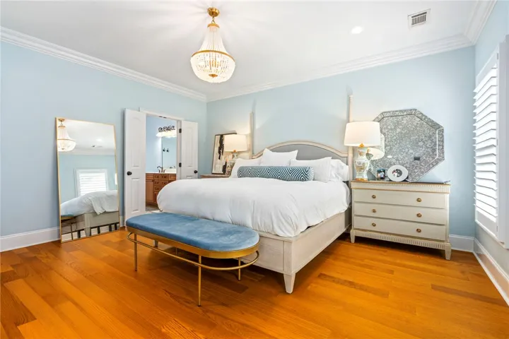 Elegant crown molding and rich hardwood flooring define this tranquil bedroom retreat.