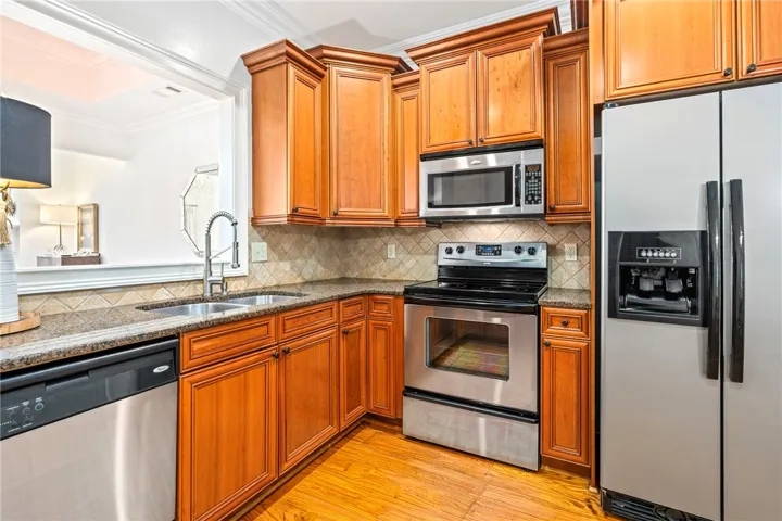 Warm wood cabinetry and durable granite counters outfit this functional, well-appointed kitchen.