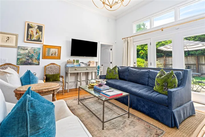 A grand living space with high ceilings and transom windows provides abundant natural light, offering direct access to the outdoors.