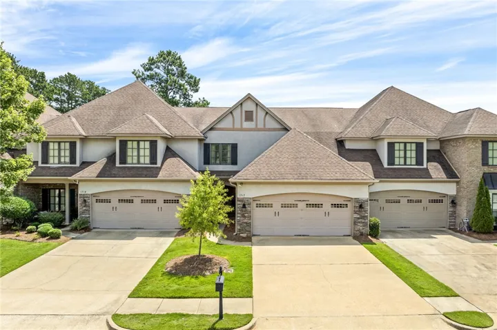 A row of inviting townhomes featuring well-maintained landscapes and dual garage doors.