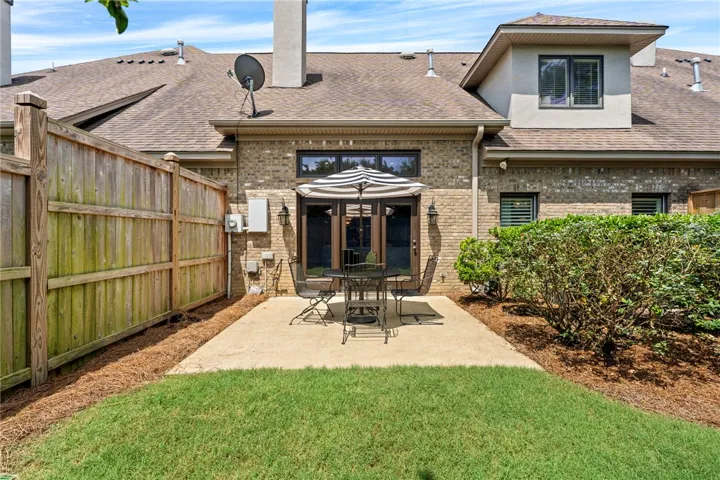 An inviting backyard patio space offers privacy for outdoor dining and relaxation.