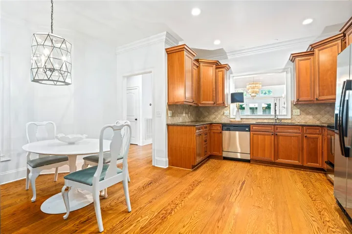 A well-lit kitchen with rich wood cabinetry and gleaming hardwood flooring.