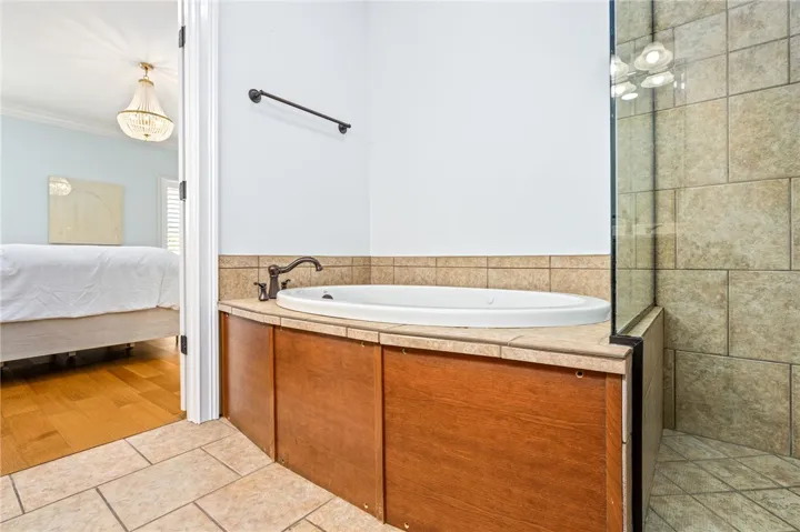Indulge in a tranquil bathing experience with this inviting built-in tub and adjacent shower.