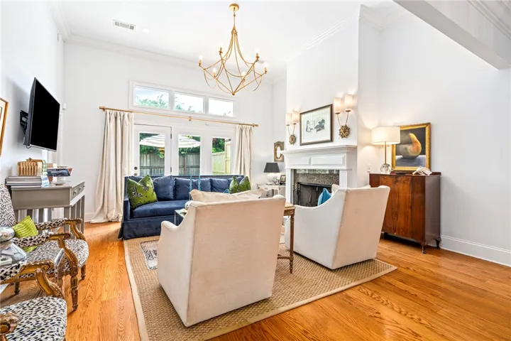 Natural light floods this inviting living space, highlighting rich hardwood floors and a classic fireplace feature.