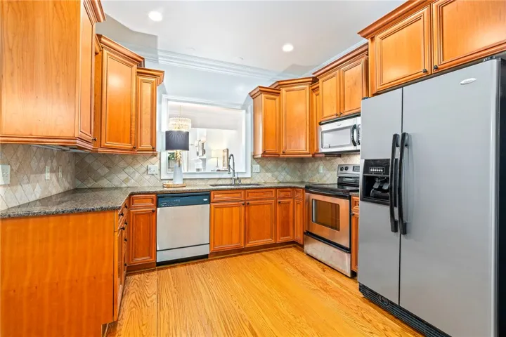 A well-appointed kitchen features stainless steel appliances, rich wood cabinetry, and elegant crown molding.