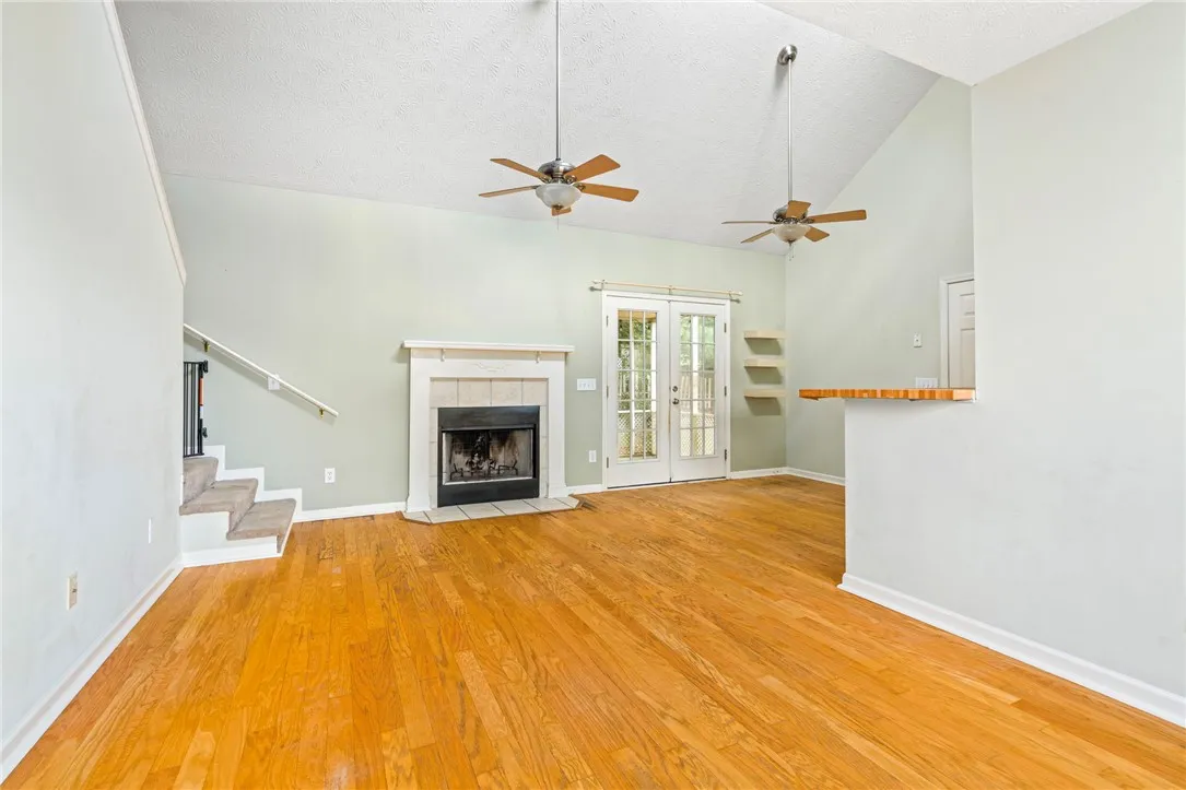 Bright hardwood floors and soaring ceilings define this inviting living space, centered around a cozy fireplace.