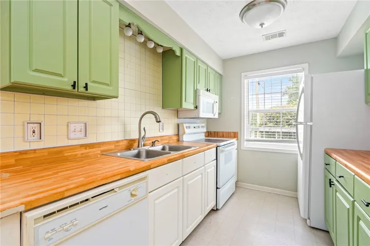 A well-equipped culinary space featuring warm wood countertops and cheerful cabinetry.