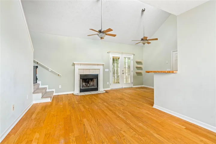 Bright hardwood floors and soaring ceilings define this inviting living space, centered around a cozy fireplace.