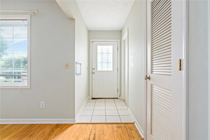 A well-lit entry hall with mixed flooring welcomes guests into this comfortable residence.
