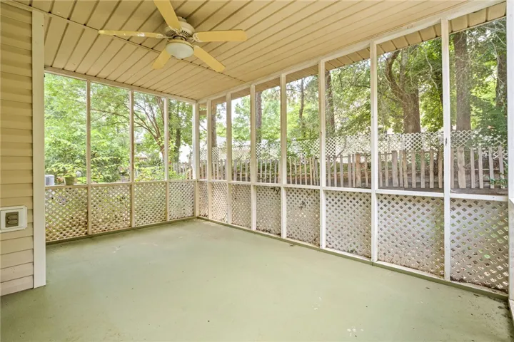 Enjoy outdoor living in this airy screened porch, offering serene views of the surrounding greenery.